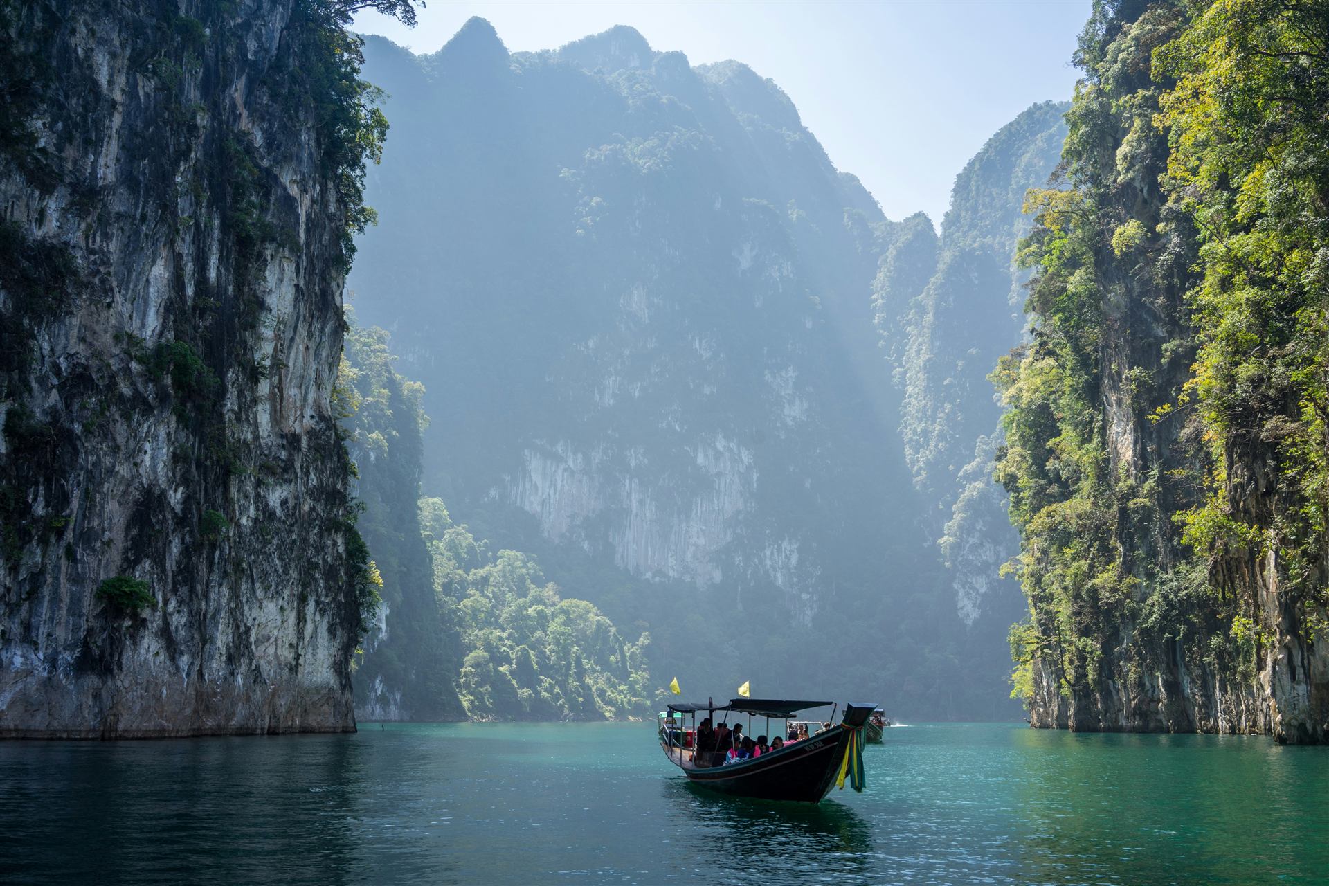 Misty limestone karsts with a longtail boat